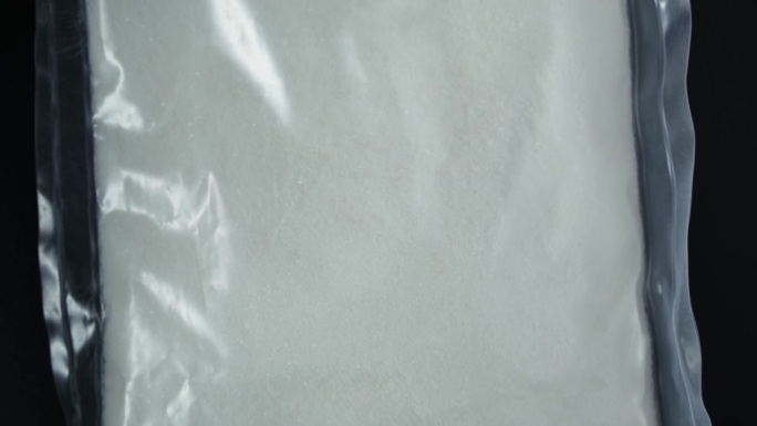 塑料袋里的柠檬酸二氢钠粉末，特写。食品添加剂E331，防腐剂和调味剂。4K视频，旋转。柠檬酸钠在食品