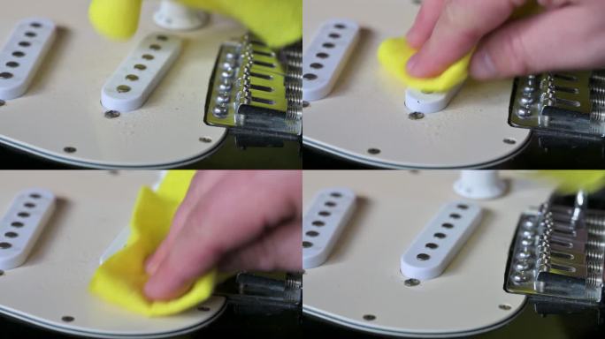 一名男子正在清洗装有白色拾音器的黑色电吉他。吉他服务理念。4k视频片段UHD 3840x2160