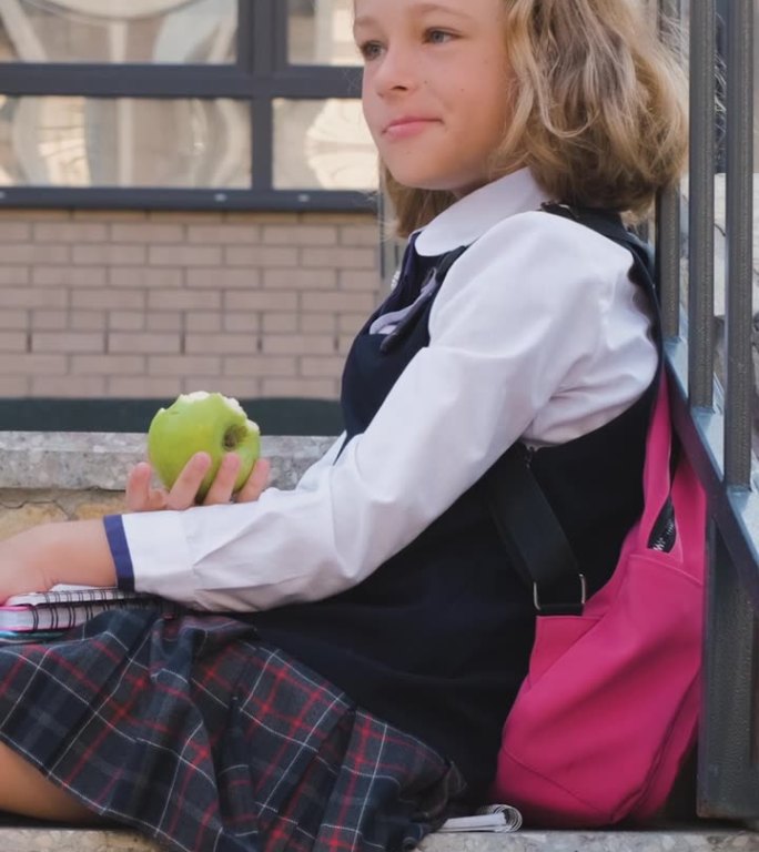 背着书包的女学生在吃苹果