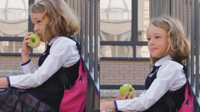 背着书包的女学生在吃苹果