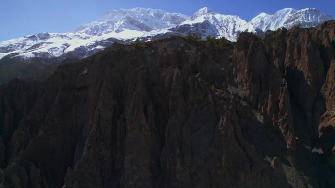 在晴朗的蓝天上，从空中俯瞰喜马拉雅山脉的岩石和雪峰。雄伟壮丽的尼泊尔喜马拉雅山脉背景。