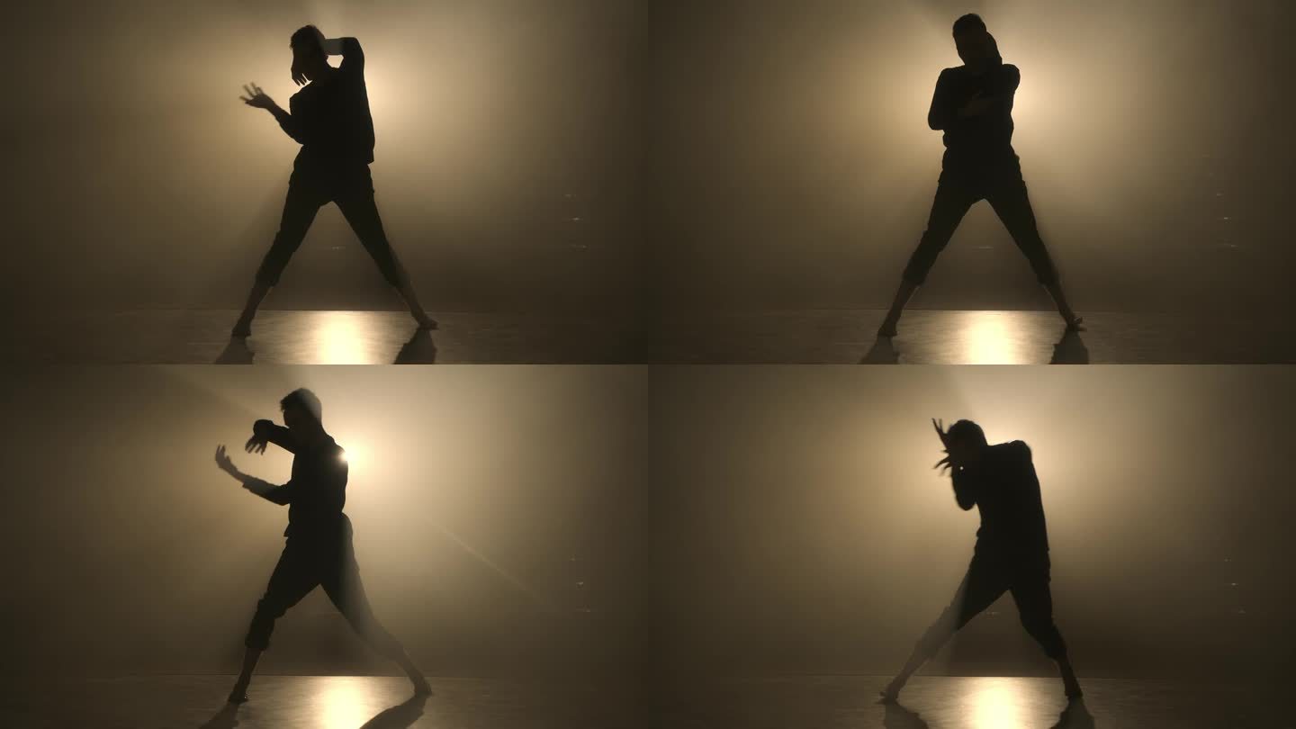 美丽的舞蹈背景慢动作，艺术4K概念。一个翩翩起舞的男人的剪影。优雅的男性在摄影棚里跳舞，背景是烟雾中