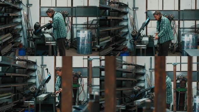在制造工厂，年轻男工人边抽烟边用带锯锯金属