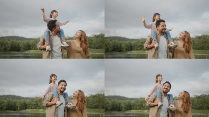 幸福家庭的特写，亚洲的小女儿坐在她父亲的肩膀和脖子上玩耍，一起假装飞翔。