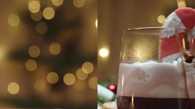 垂直视频。姜饼饼干和棉花糖和一杯热巧克力散落在桌子上。背景是一棵挂满花环的圣诞树，营造出温馨舒适的家