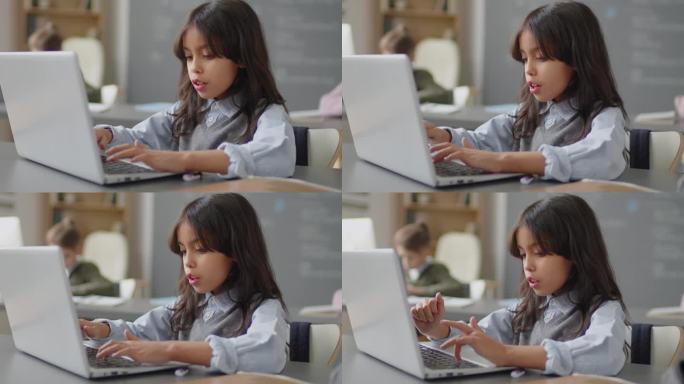 西班牙女孩在学校用笔记本电脑键盘打字