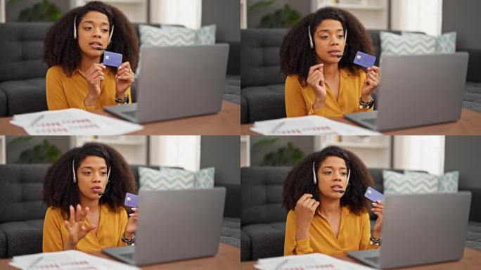 非裔美国女性呼叫中心话务员手持信用卡在家工作，进行视频通话