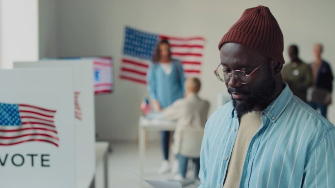 美国选举日，年轻黑人男子在投票站微笑的肖像