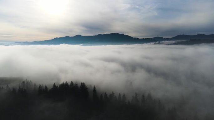 飞过山顶的云层。山峰高耸，清晨日出，自然景观优美