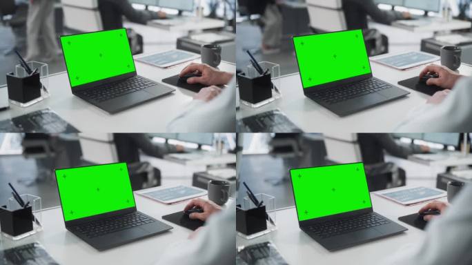 成功的白人商人坐在办公桌旁用绿屏笔记本电脑工作。匿名商人使用色度键显示。时尚明亮的工作场所。过肩特写