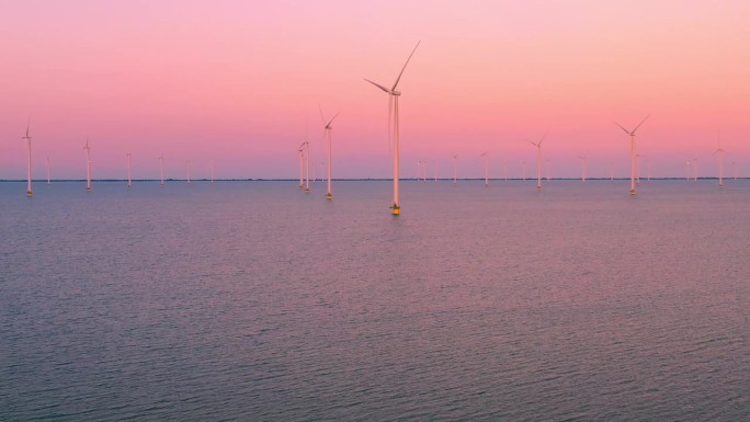 荷兰日落时海上风力涡轮机公园的空中无人机视图。绿色可再生能源理念。
