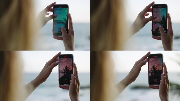 女子手持智能手机，记录热带岛屿的自然风光。手机屏幕上有蓝色的岩石海洋，蓝色的多云天空和绿色的棕榈树景