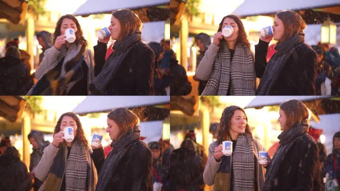 冬天的晚上，两位妇女在假日市场上享用热饮