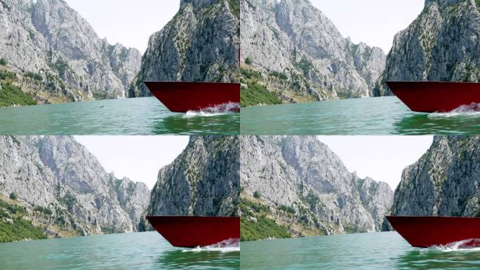 阿尔巴尼亚，科曼湖，湖面上一艘红船的船头，背景是被诅咒的山脉