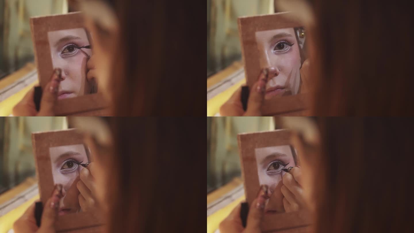 这是一个女孩用眼线液画眼线时镜子里的眼睛特写