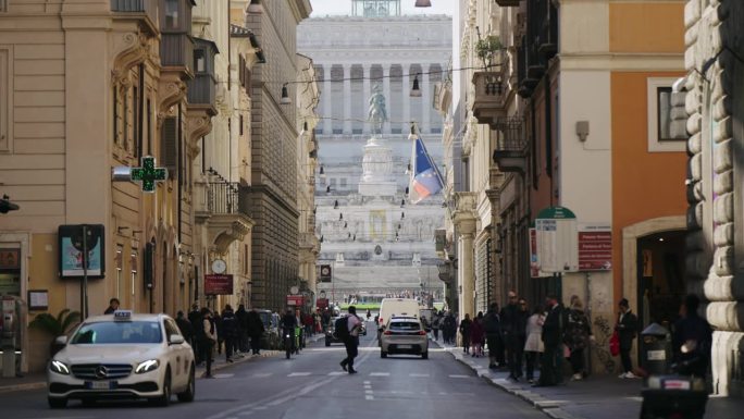 罗马街头的人们和交通的生活场景，背景是意大利罗马的威尼斯广场和祖国祭坛与维托里奥·伊曼纽尔二世纪念碑