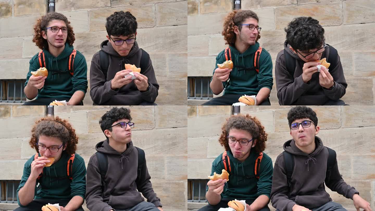 2023年8月1日,德国纽伦堡市。两个年轻的白种人正在享用夹着典型的纽伦堡香肠的三明治。他们边吃边评