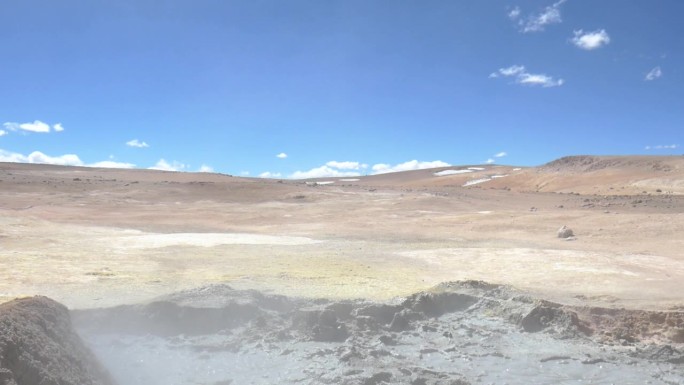 玻利维亚和智利边境沙漠的广角镜头，前景是一个泥泞的火山池。