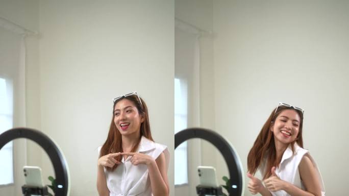 亚洲年轻女性网红在社交媒体上分享舞蹈内容和故事。博主拍摄了她在智能手机社交网络上跳舞的垂直视频。