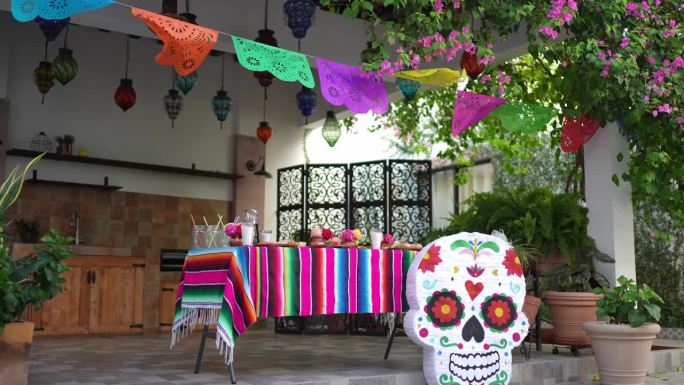 桌子上有装饰品，食物和糖头骨piñata为亡灵节