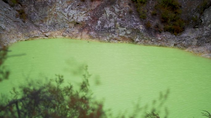 位于新西兰罗托鲁瓦(waio - o - tapu)的Devi's Bath霓虹绿色硫磺湖，一个地热