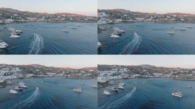 日落时分米科诺斯岛海岸线上游艇的航拍视频