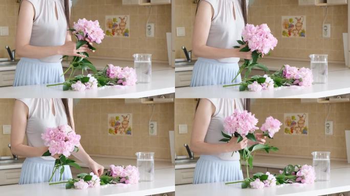一位年轻女子在家里的花瓶里插花。牡丹花朵。