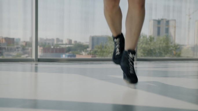 运动员在健身房训练时，穿着跳绳运动鞋的男脚低拍
