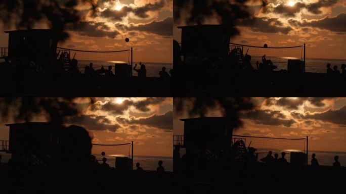 日落时沙滩排球的剪影。