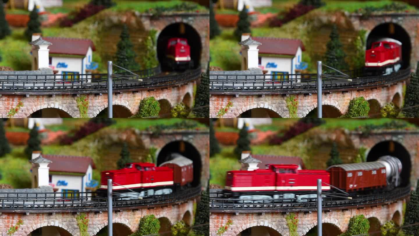 模型货运列车驶出隧道，通过一座桥。铁路模型。