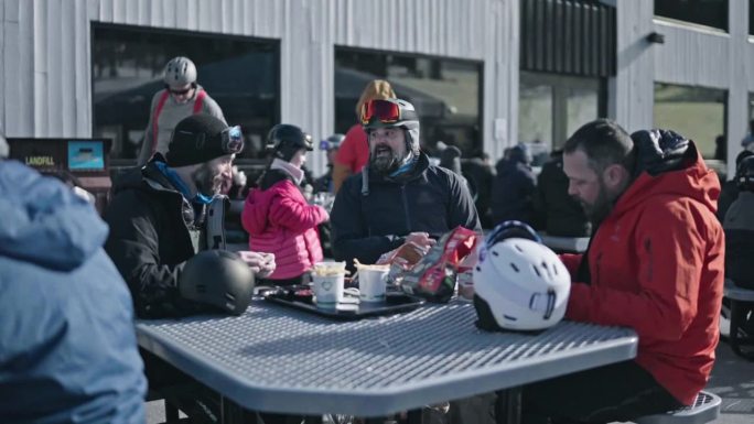 朋友们在滑雪小屋外面吃午饭
