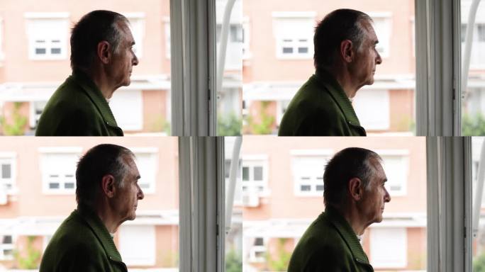 有老年痴呆症和抑郁症的老人，侧身看着窗外。老年，疾病，孤独，健忘和记忆的概念。