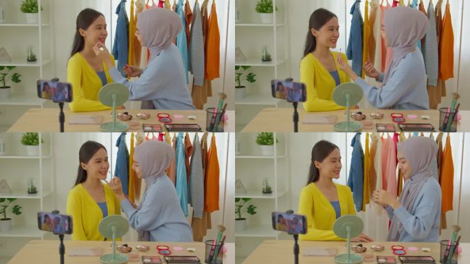穆斯林年轻女博主在活动中用她的智能手机为客户录制化妆视频。年轻的穆斯林女性化妆老师用智能手机在自己的