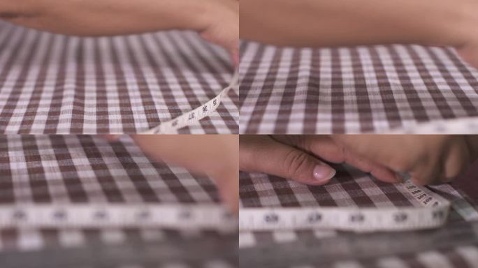 女裁缝正在用卷尺量格子布的尺寸，并在上面画上点，以便裁剪。