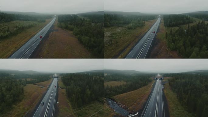 雨天行驶在森林间高速公路上的红色旅行SUV鸟瞰图