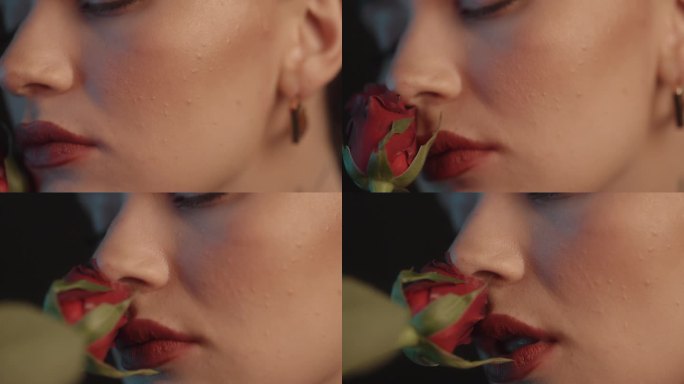 美丽性感的女人与红色口红黑色背景工作室拍摄的姿势，闻着一朵红玫瑰和调情的镜头