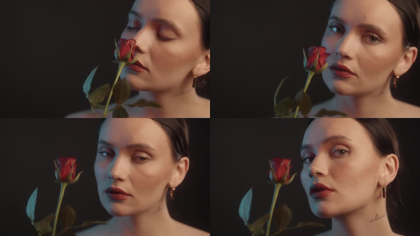美丽的感性的女人与红色的口红黑色背景工作室拍摄的单红玫瑰和调情的相机