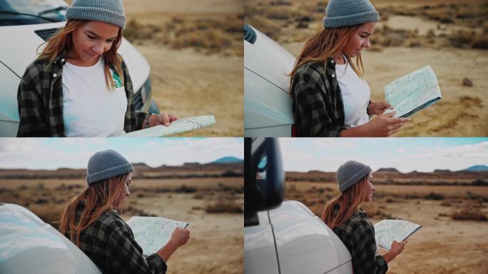 在摩洛哥沙漠的某个地方，一名妇女在一辆露营车前看地图