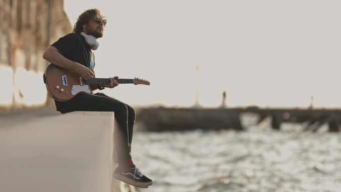 一个人坐在海边弹吉他