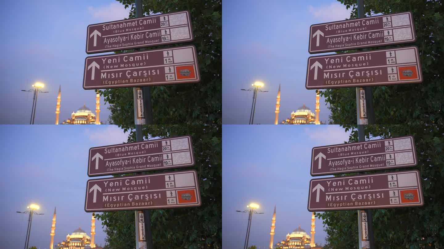 柱子上的路标显示通往蓝色清真寺的道路。背景是新清真寺。土耳其伊斯坦布尔