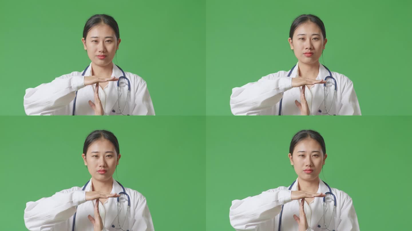亚洲女医生带着听诊器做暂停手势的特写，在医院的绿屏背景上