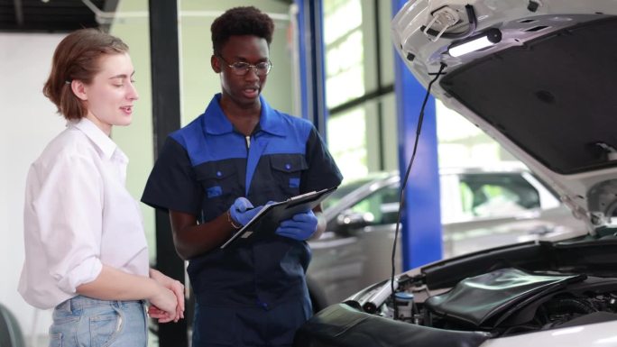 汽车建议:机械师在汽车修理厂向顾客解释汽车的特点-专家汽车维修和检查