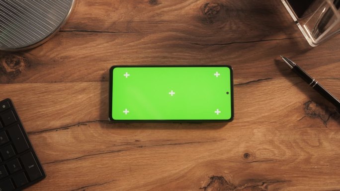 一个智能手机与模拟绿色屏幕Chromakey显示与运动跟踪占位符的自上而下的视图。一个手机设备水平躺