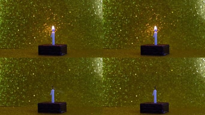 一支燃烧的蜡烛在小小的生日蛋糕上，金色闪闪的背景和串灯闪耀