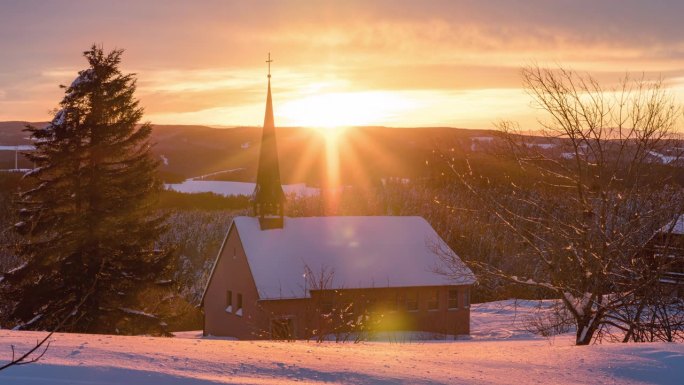 冬天，夕阳落在村庄上空，可以看到教堂
