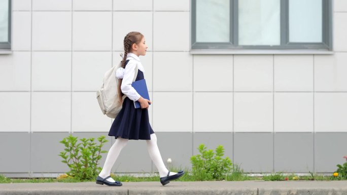 女学生背着书包和书去上学