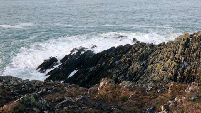 崎岖的海岸线，布满锯齿状的岩石，勇敢地面对海浪的无情冲击。湛蓝的大海形成了令人惊叹的背景。