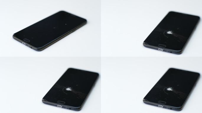 破碎的黑色触屏手机孤立在白色背景上。因撞击或锤击而有裂缝的碎玻璃。智能手机损坏，触摸屏被蜘蛛网划伤。