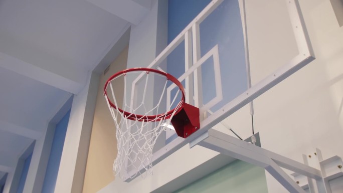 体育馆的透明塑料防护罩上带网的篮筐