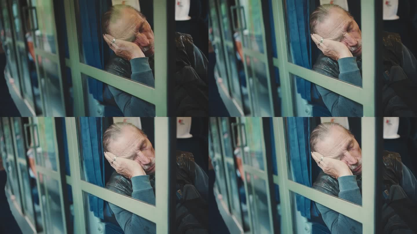 老人在火车上睡觉，透过双层玻璃看
